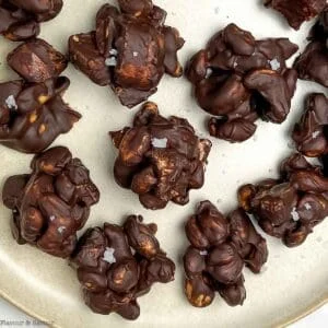 Chocolate cashew clusters on a plate.