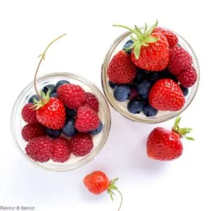 Overhead view of two jars of no bake cheesecake with fresh berries
