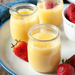 small jars of lemon curd with fresh strawberries