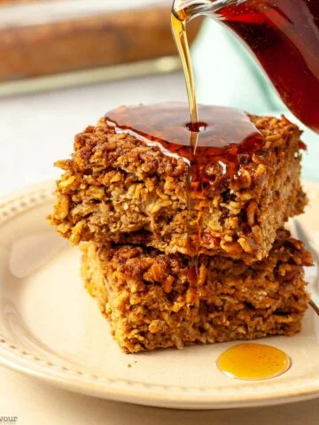Two squares of pumpkin baked oatmeal with maple syrup