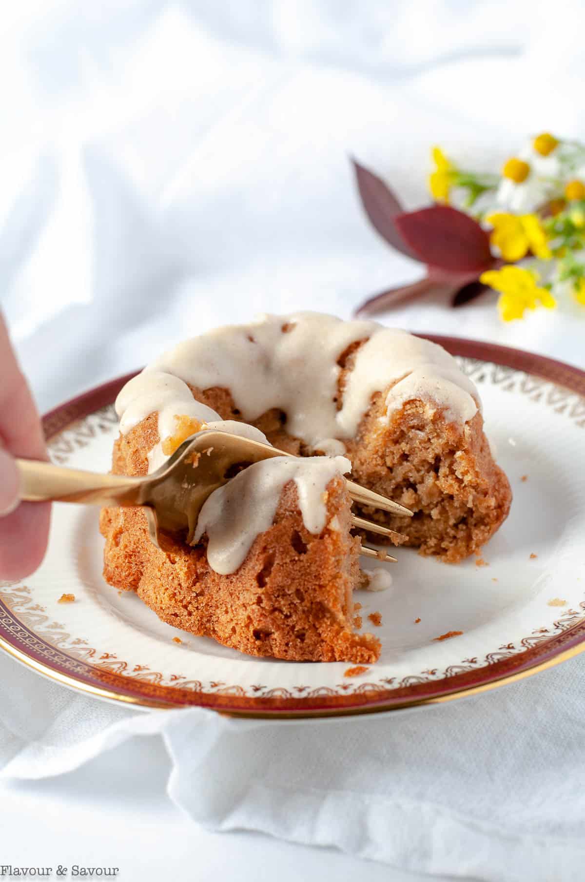 https://www.flavourandsavour.com/wp-content/uploads/2020/10/Cutting-into-a-Mni-Apple-Bundt-Cake-with-a-fork.jpg