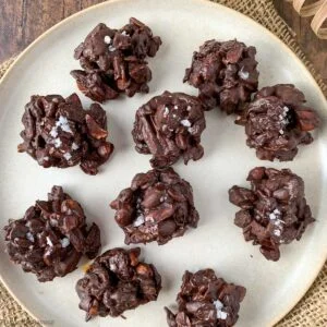 chocolate nut clusters with nuts, seeds and dried fruit on a plate