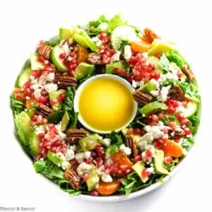 Overhead view of a Christmas Wreath Salad with romaine, avocado, oranges, pecans and feta.