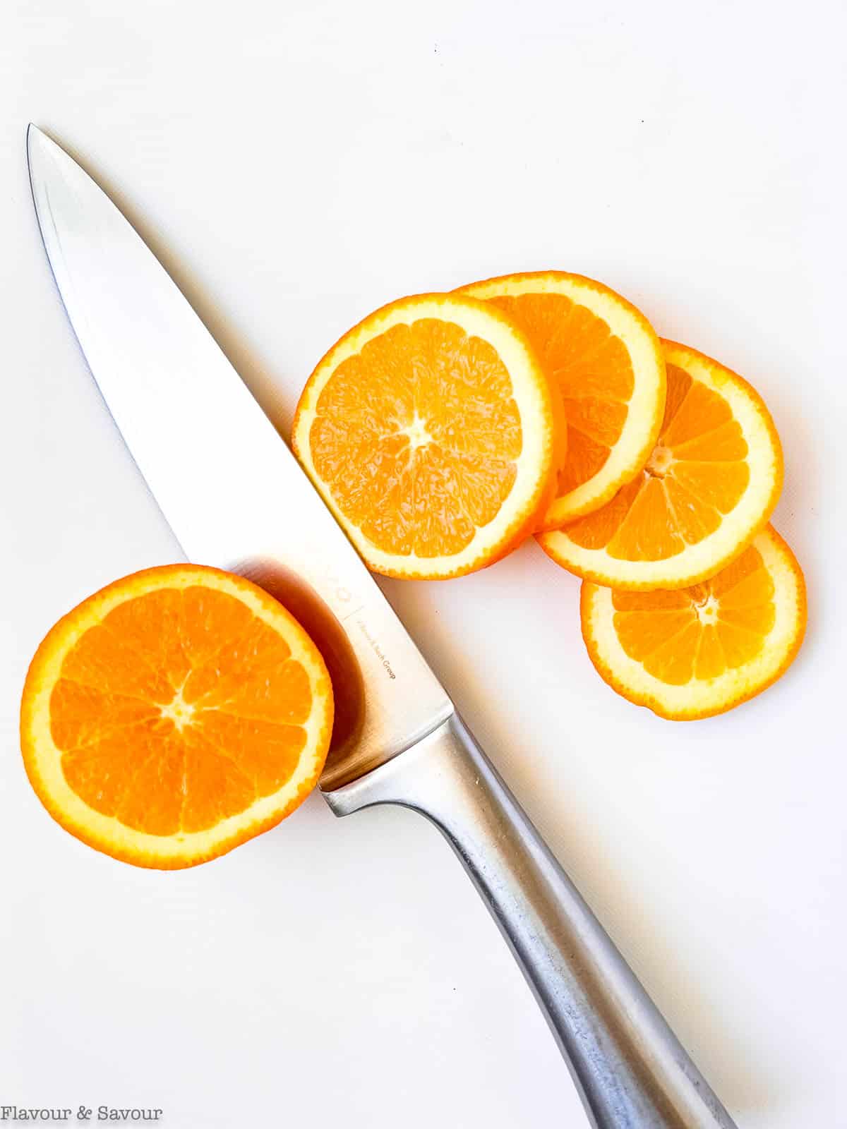 https://www.flavourandsavour.com/wp-content/uploads/2022/08/slicing-oranges-for-dried-orange-slices.jpg