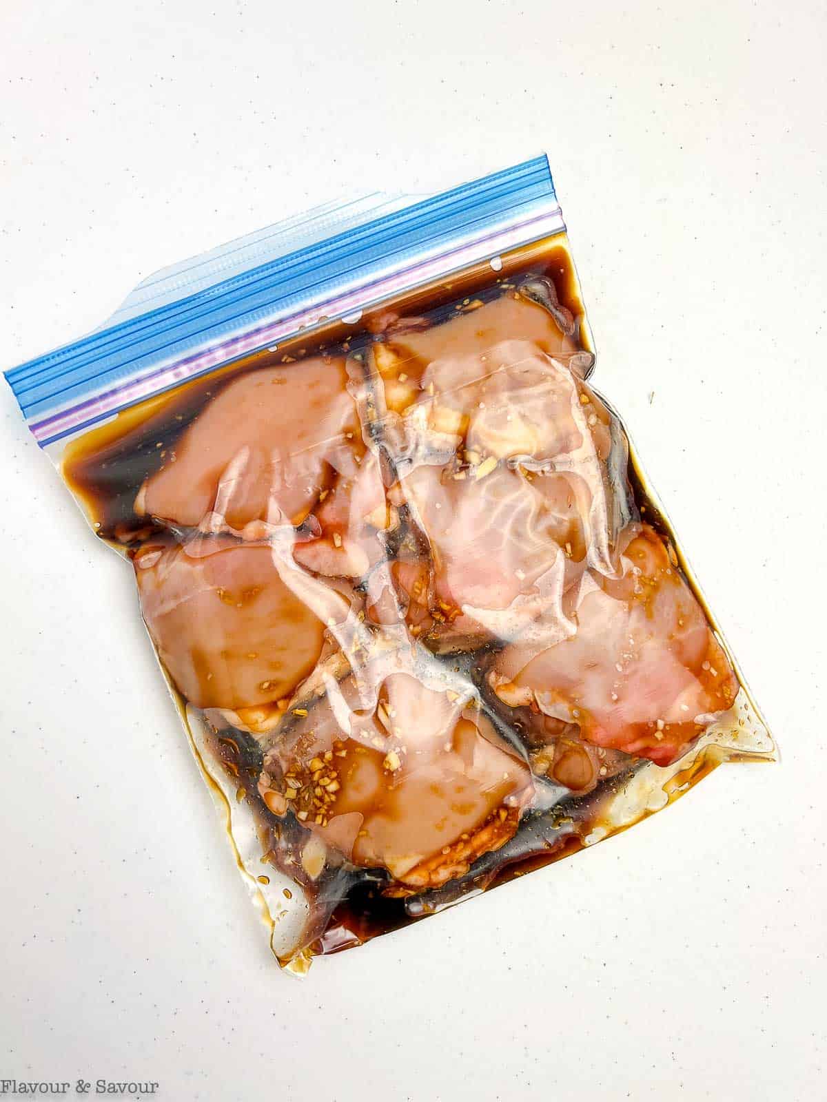 Chicken thighs with teriyaki marinade in a resealable bag.