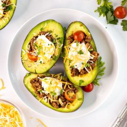 Avocados stuffed with taco filling and sour cream, cheese and tomatoes.