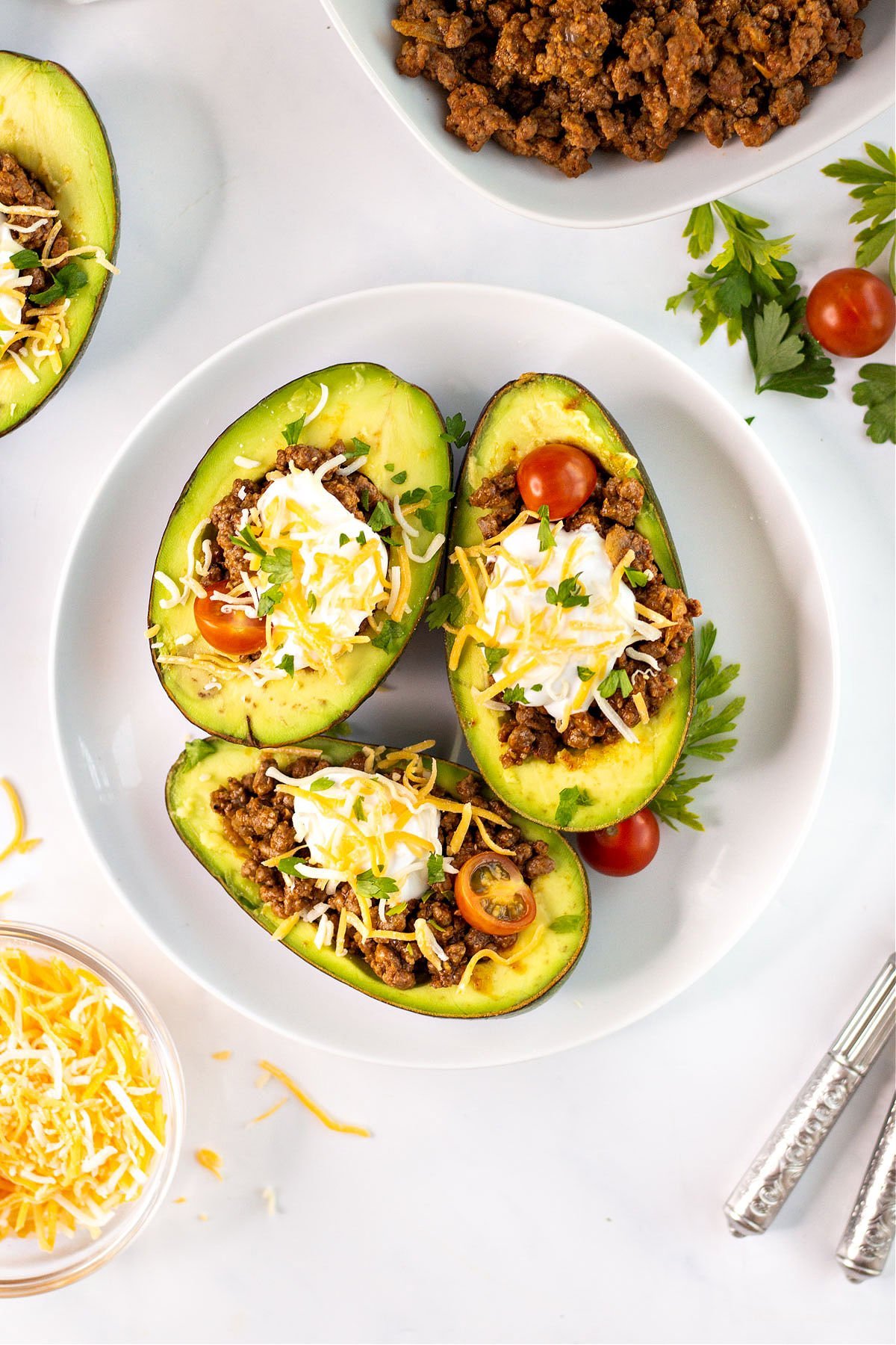 Avocados stuffed with taco filling and sour cream, cheese and tomatoes.