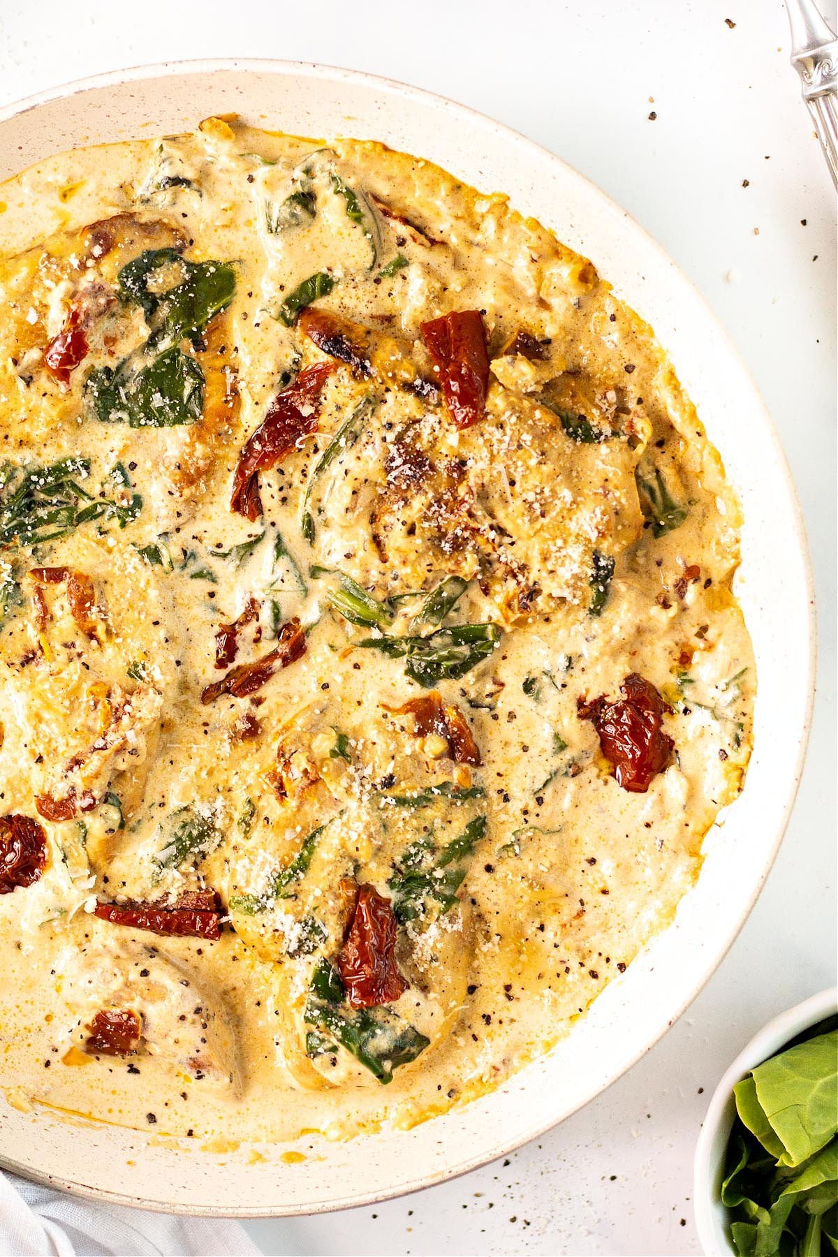 Keto tuscan chicken in a white serving bowl.